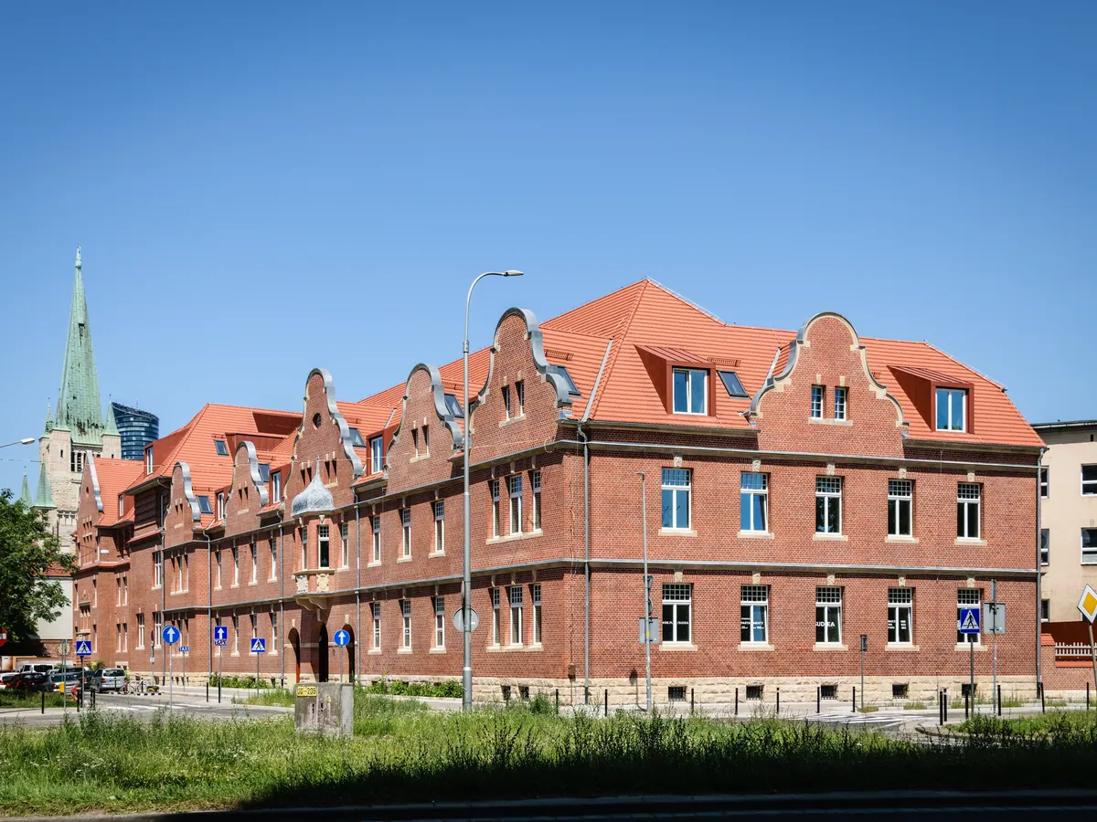 Denkmalgeschütztes Backsteinensemble mit weißen Sprossenfenstern
