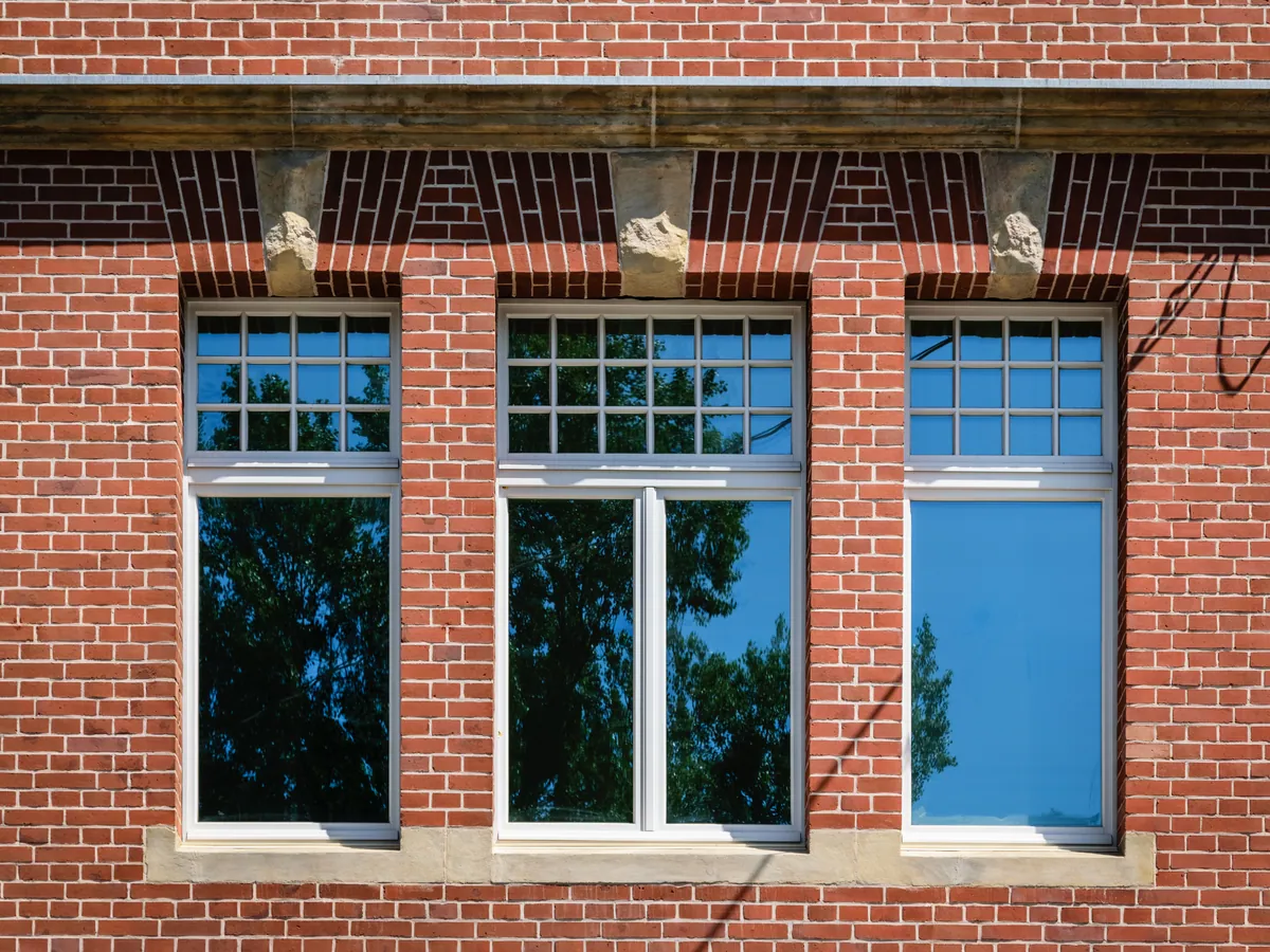 Dreiteilige Sprossenfenster in einer Backsteinfassade
